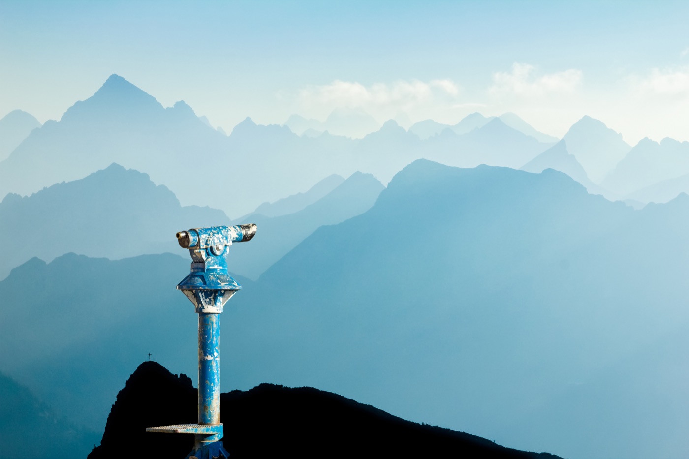 A misty mountain vista, viewed through a lookout point telescope